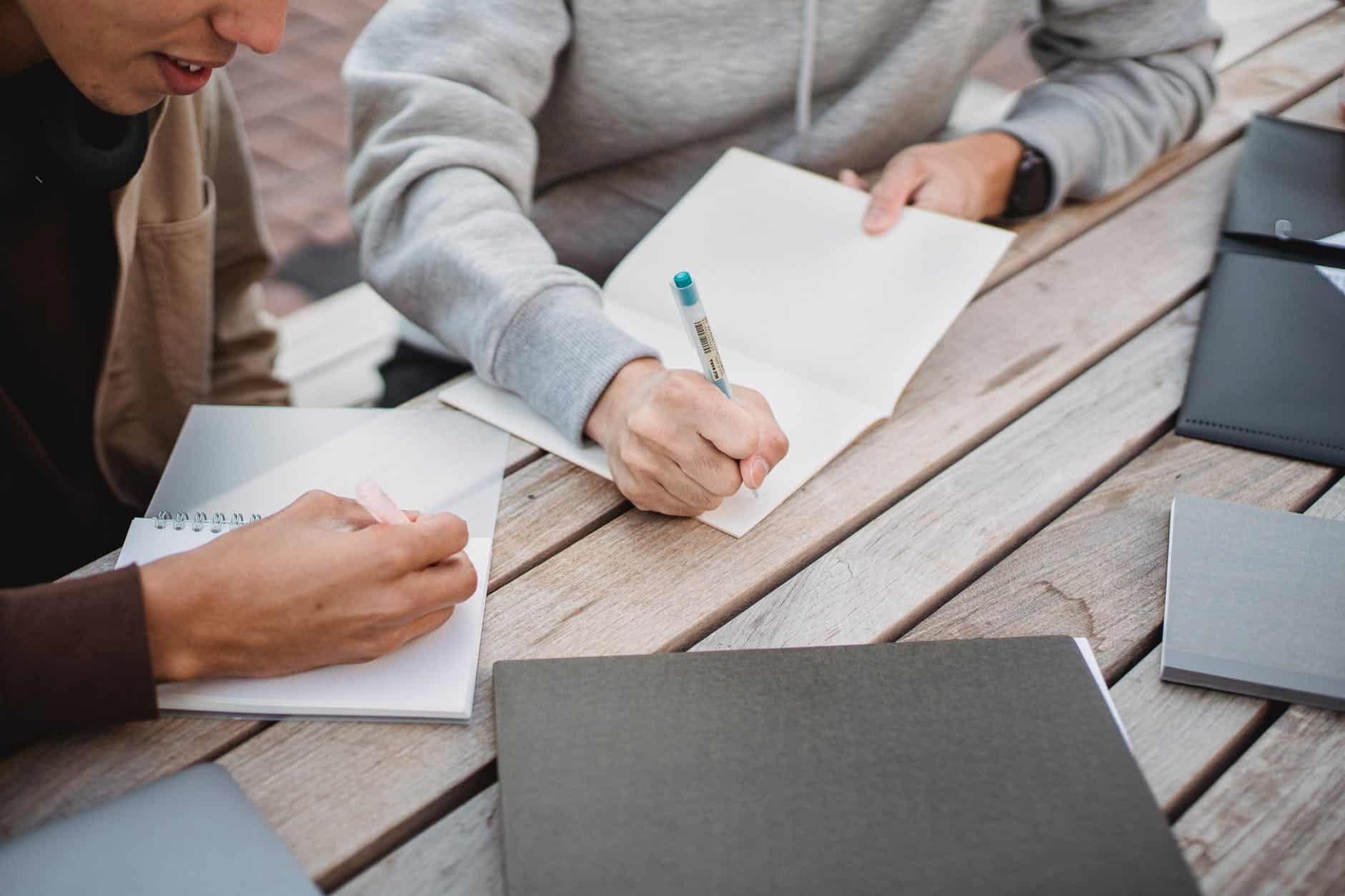 《統合心智》讀後心得:21 世紀最重要的心智模型 3 crop unrecognizable male students writing essay in park