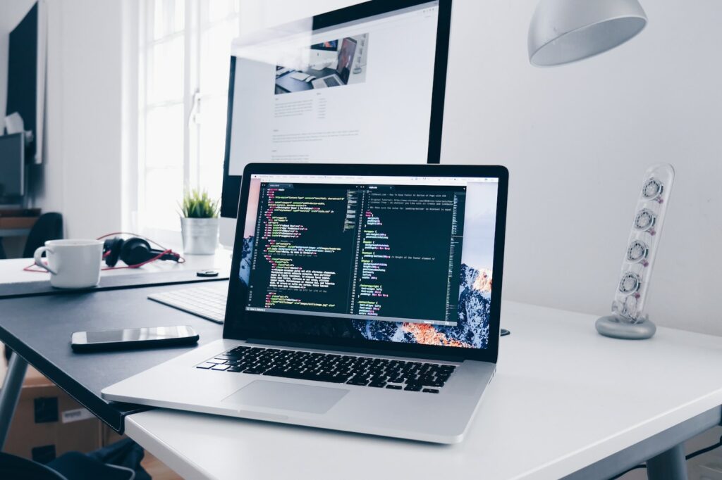 《你拿什麼定義自己?》讀後心得和四個重點整理 3 A MacBook with lines of code on its screen on a busy desk