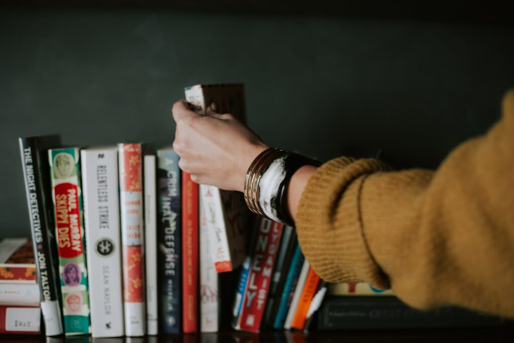 《療心圖書館》讀後心得:不要小看自己的力量 3 person picking white and red book on bookshelf