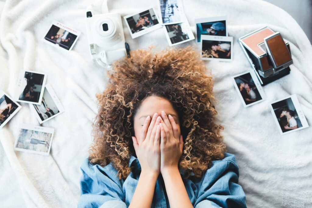 《第二大腦》讀後心得:本書特色和帶給我的三個啟發 3 woman lying on bed covering her face surrounded by photos and white camera
