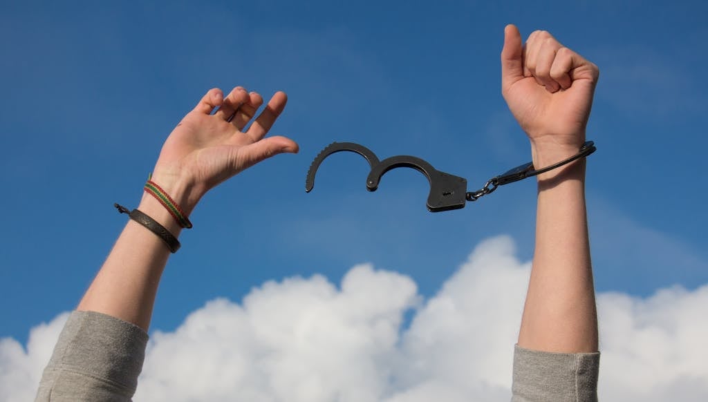 《財富喜悅》讀後心得:學會跟錢好好相處的行動手冊 4 Symbolic image of freedom with open handcuffs against a bright blue sky.