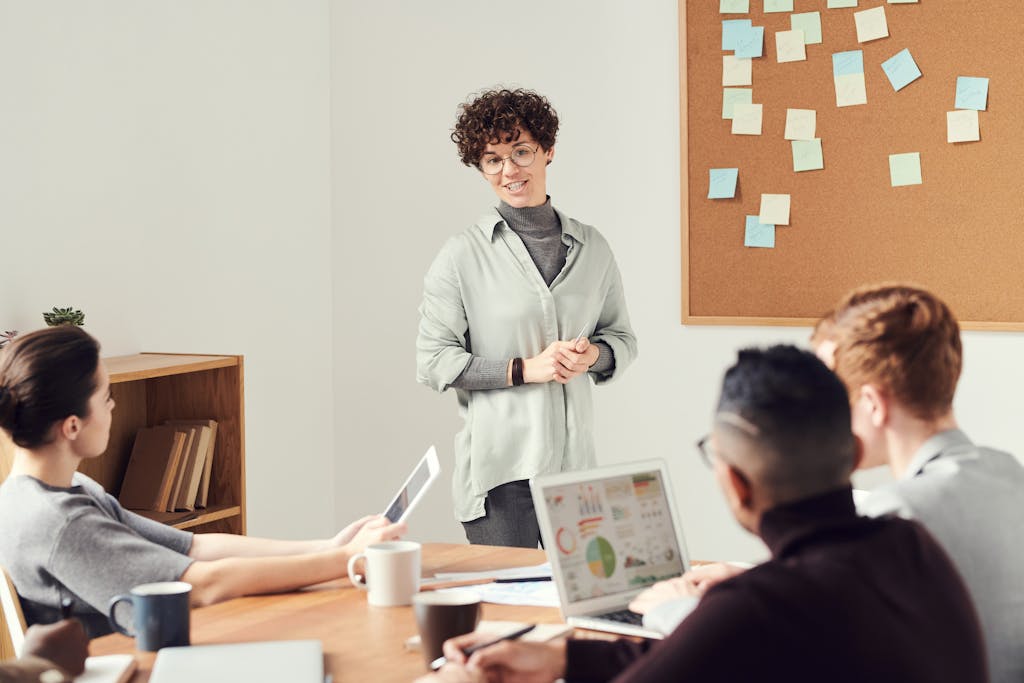 《請開始說你的故事》讀後心得:說好故事的五個方法 4 Diverse team discussing ideas during an office meeting with charts displayed on laptops.