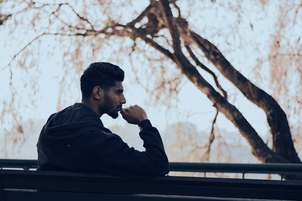 《佛畏系統》讀後心得:被書名耽誤的好書與三個實用觀念 2 Man in deep thought sitting on a bench in a serene autumn park setting.